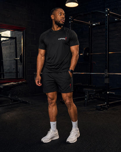 Aspire1 Tech T in black, worn with training shorts in the gym